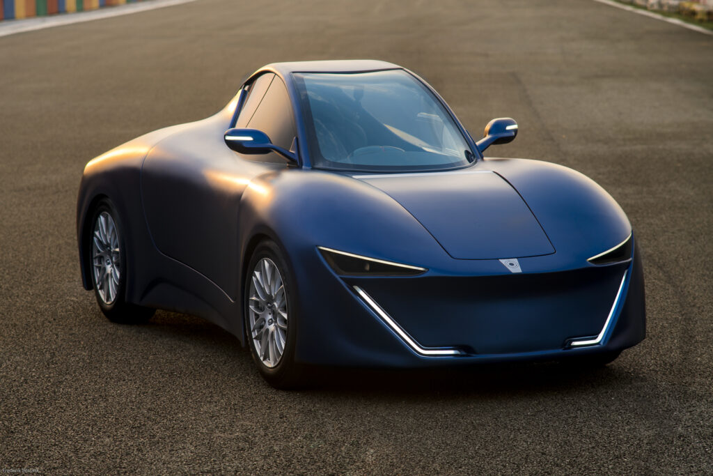Front three quarter profile of the Quanta EV on the track at sunset.