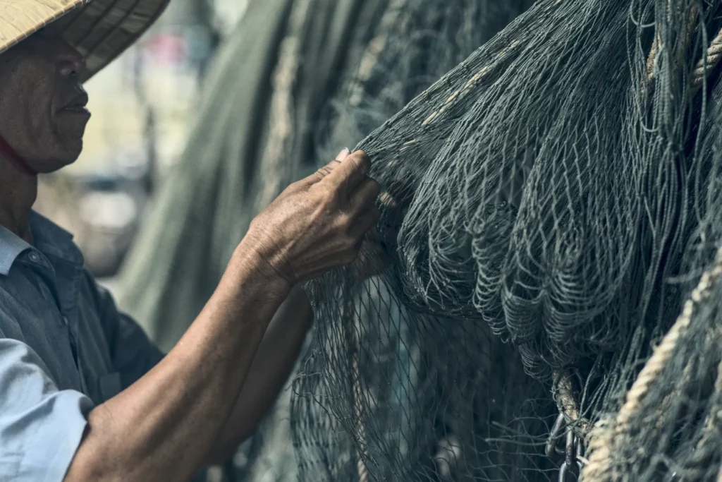 weathered hands repairing nets